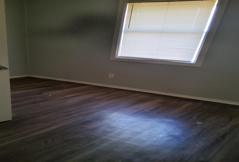 Empty room featuring baseboards and dark wood-style floors