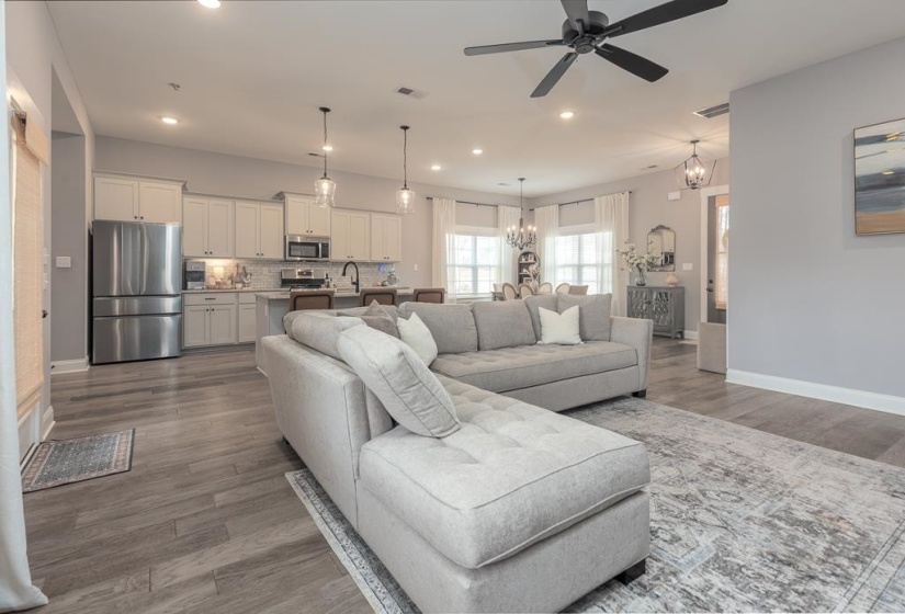 Living room with wood finished floors, recessed lighting, a chandelier, and a ceiling fan