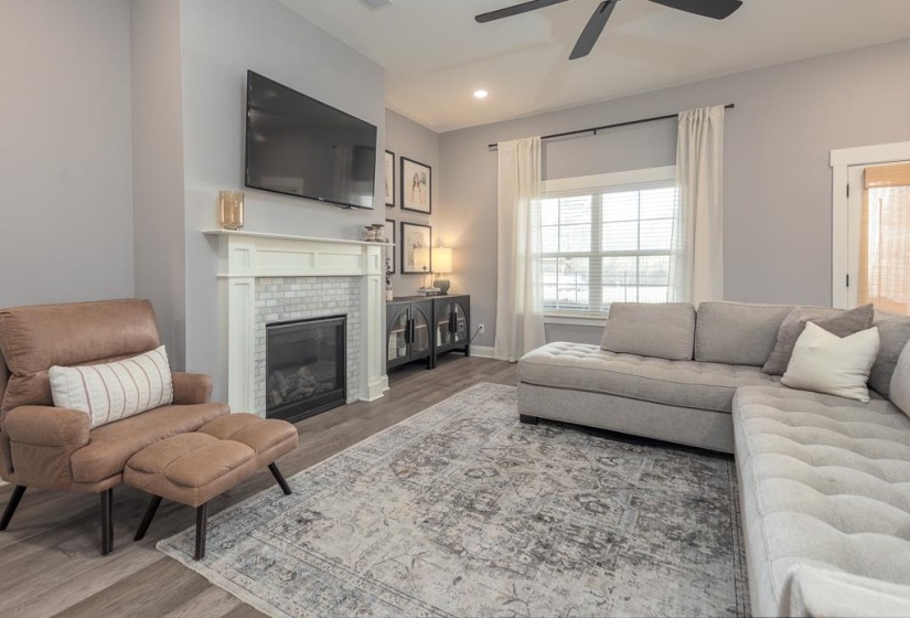 Living area with wood finished floors, a tile fireplace, recessed lighting, and ceiling fan