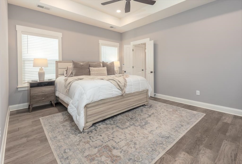 Bedroom featuring a raised ceiling, a ceiling fan, recessed lighting, and wood finished floors