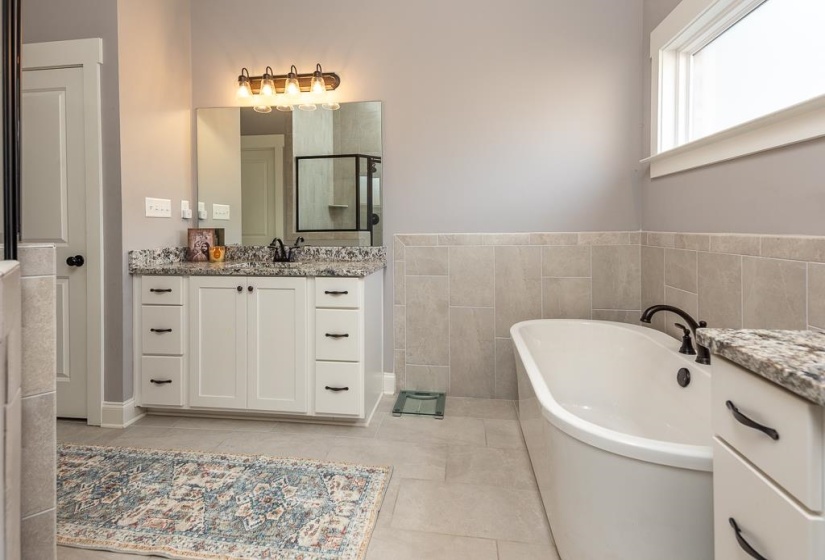 Full bathroom with vanity, a soaking tub, a stall shower, tile walls, and light tile patterned floors