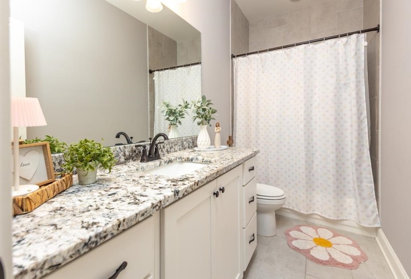 Bathroom featuring vanity, light tile patterned flooring, and shower / bath combo with shower curtain