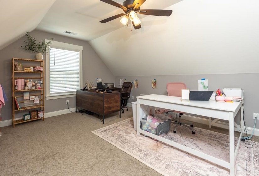 Office space featuring vaulted ceiling and light colored carpet