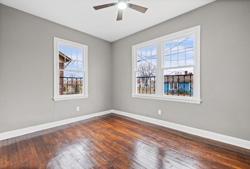 Unfurnished room featuring dark wood finished floors, a textured wall, plenty of natural light, and a ceiling fan