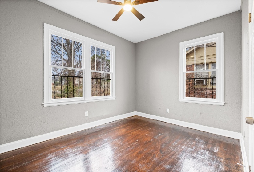 Spare room with dark wood-style flooring, ceiling fan, and a textured wall