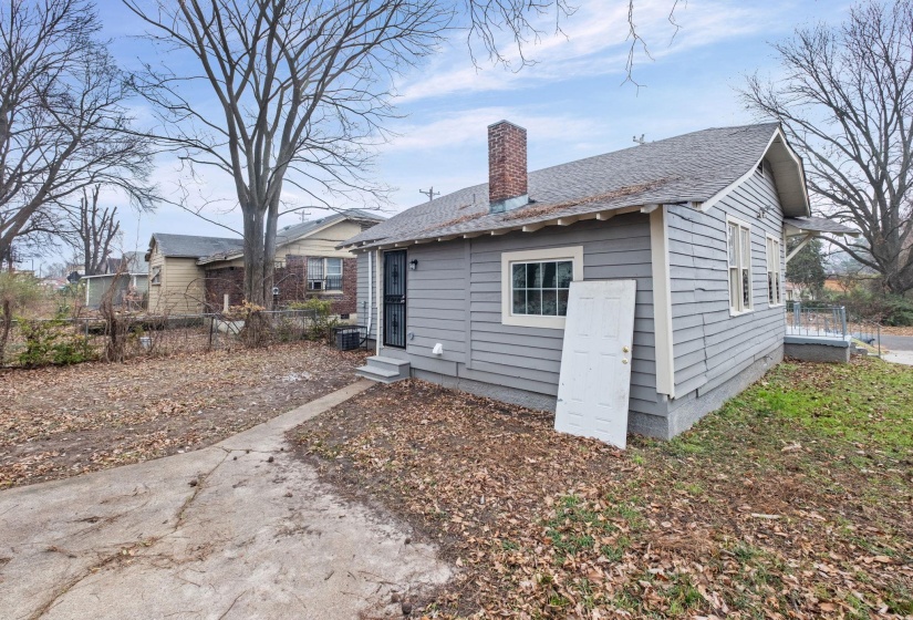 Rear view of house with a chimney, roof with shingles, and entry steps