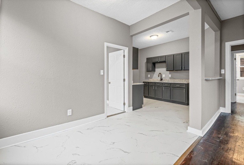 Kitchen featuring a textured ceiling, light stone countertops, and gray cabinets