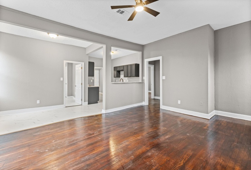 Unfurnished living room featuring dark wood-style floors and ceiling fan
