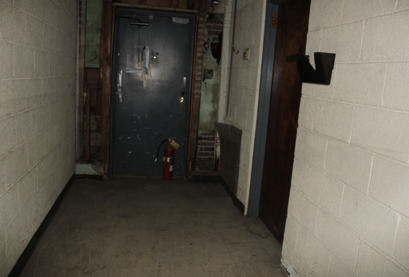 Hallway featuring concrete block wall