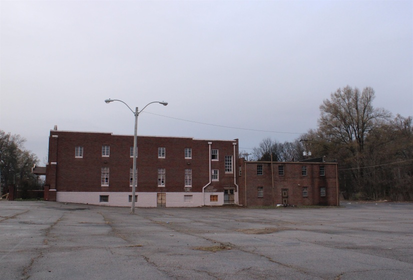 View of apartment building / complex featuring uncovered parking