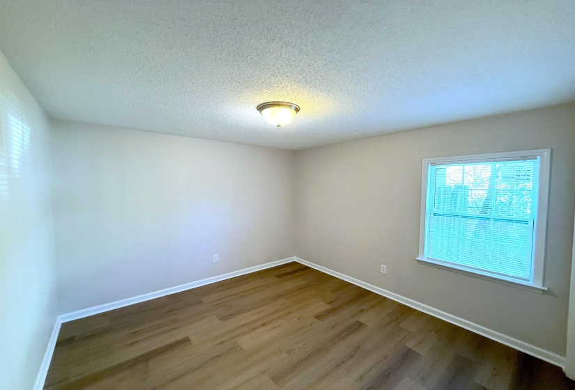 Spare room with a textured ceiling and dark wood finished floors