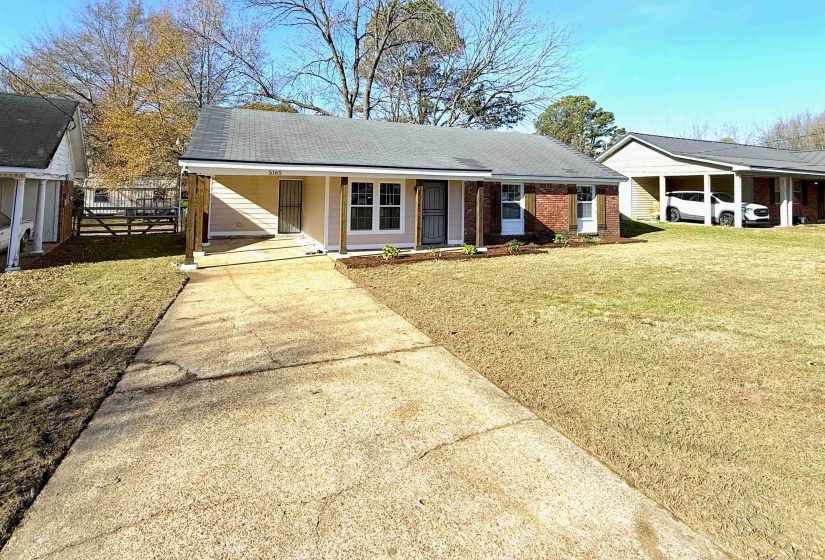 Ranch-style home with concrete driveway, an attached carport, covered porch, and roof with shingles