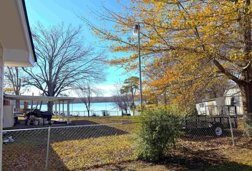 View of yard with a deck with water view