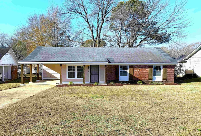 Ranch-style home with a front lawn, concrete driveway, a porch, brick siding, and an attached carport