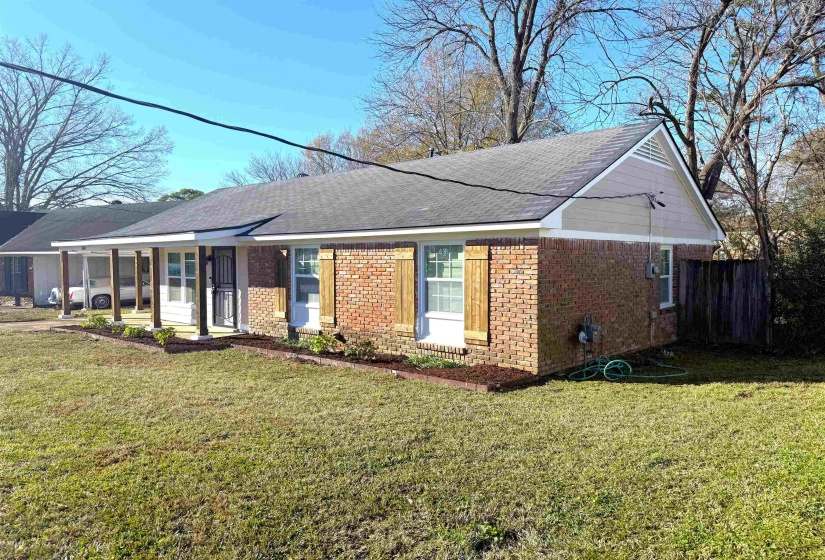 View of front of property with brick siding, a porch, and a shingled roof
