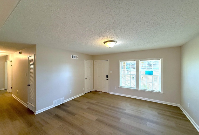 Entrance foyer with a textured ceiling and wood finished floors
