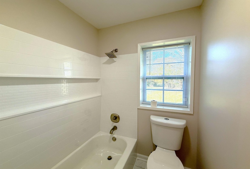 Bathroom featuring tub / shower combination and toilet