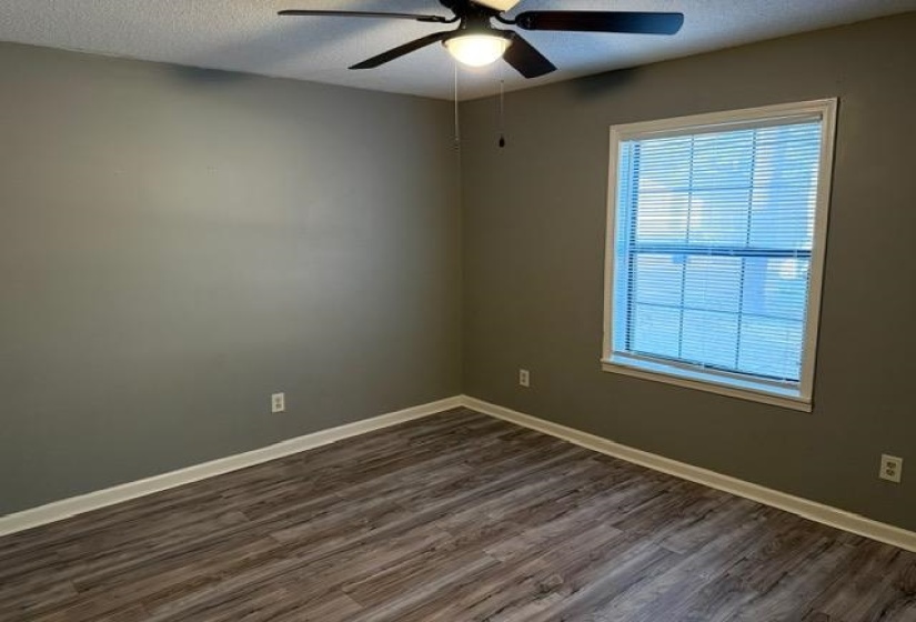 Spare room with a textured ceiling, dark wood-style flooring, and a ceiling fan