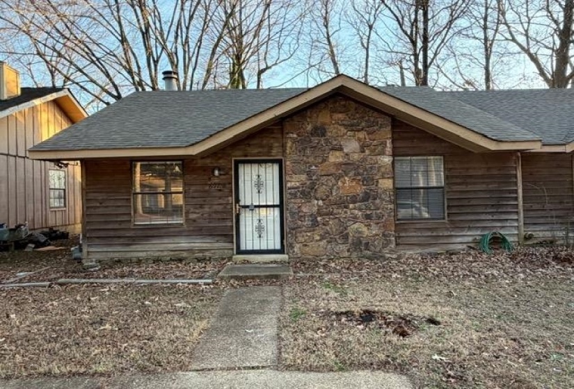 View of front of property with a shingled roof and stone siding