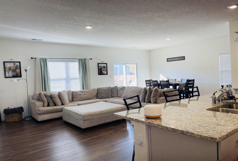 Living room featuring a textured ceiling and dark wood-type flooring