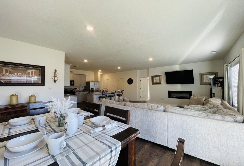 Dining area with recessed lighting, dark wood-style flooring, and a glass covered fireplace