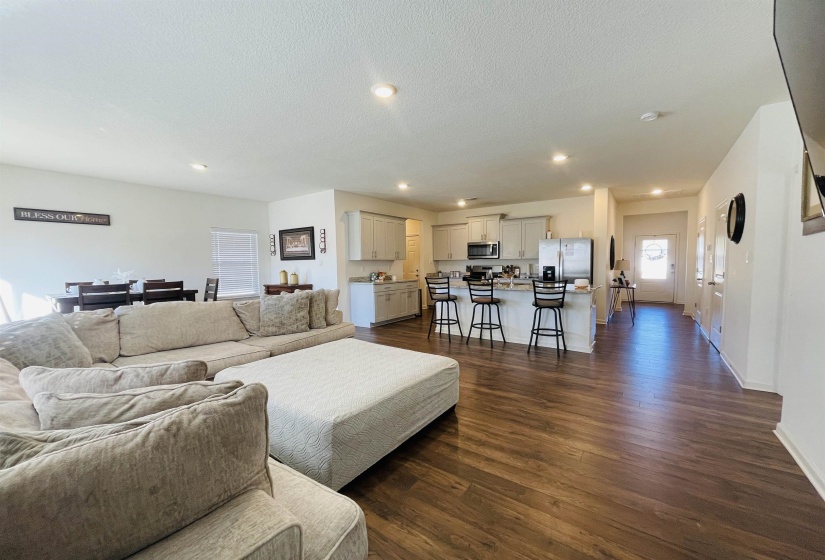 Living area with dark wood-style floors, a textured ceiling, and recessed lighting
