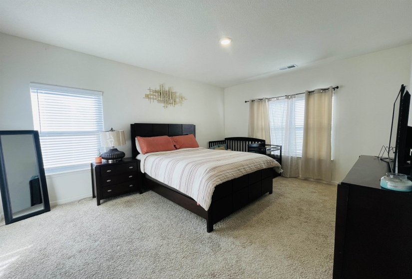 Bedroom featuring light colored carpet and baseboards