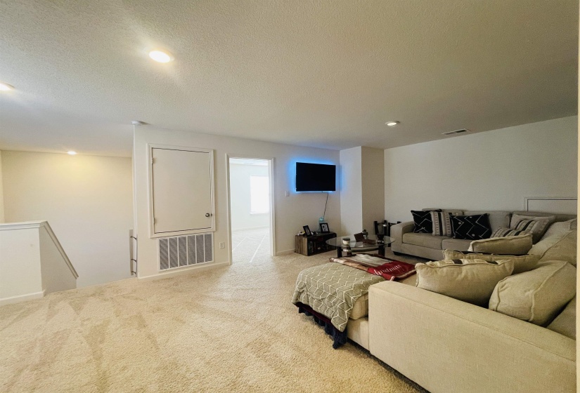Living area featuring recessed lighting, a textured ceiling, and carpet