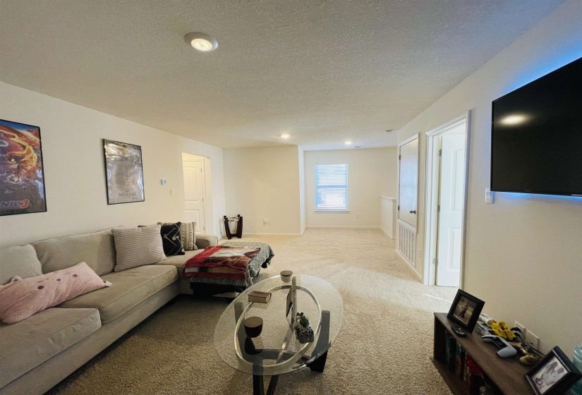 Living room with a textured ceiling, carpet, and recessed lighting