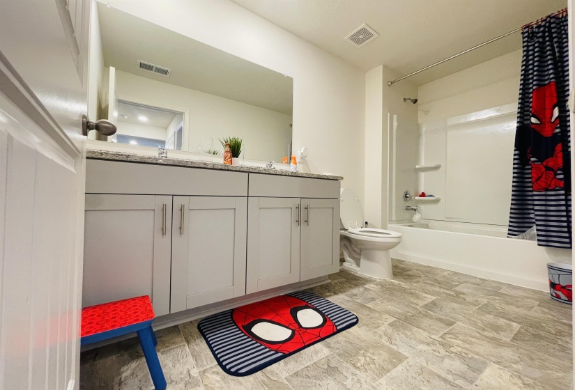 Bathroom with shower / bath combo and double vanity