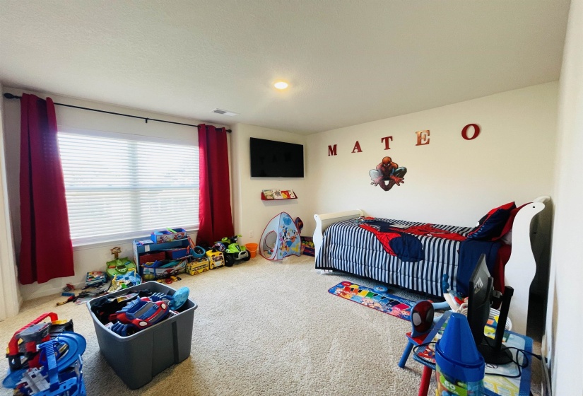Bedroom featuring carpet flooring and a crib