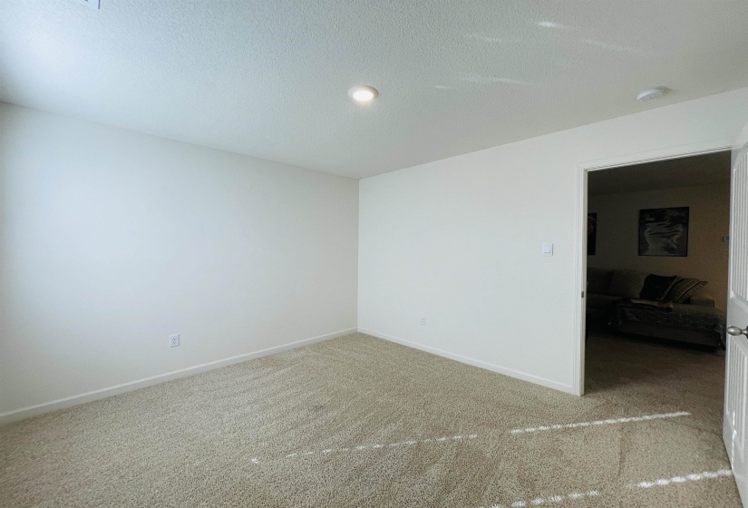 Empty room featuring a textured ceiling and carpet floors