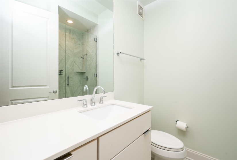 Full bath with a marble finish shower and vanity