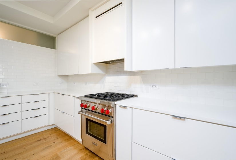 Kitchen featuring modern cabinets, white cabinets, and luxury range