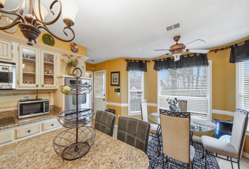 Dining space featuring a chandelier, ceiling fan, and a textured ceiling