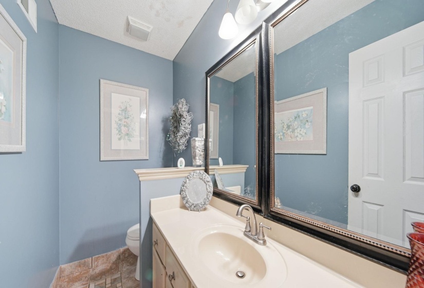 Half bath with vanity and a textured ceiling