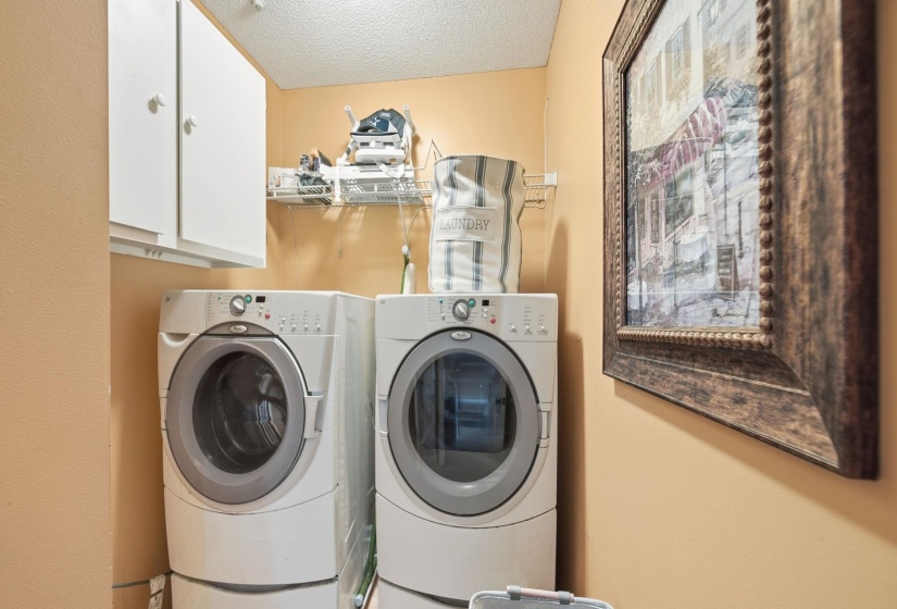 Laundry area featuring a textured ceiling, independent washer and dryer, and cabinet space