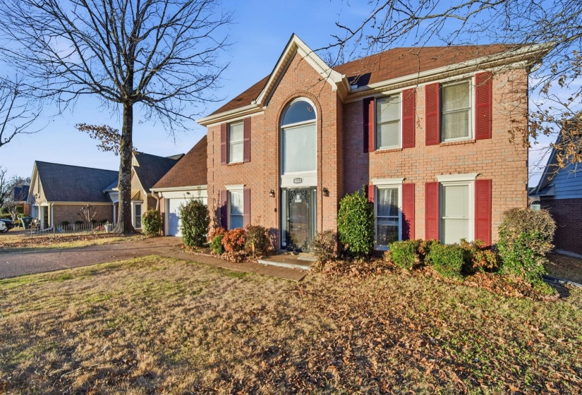 View of front of home with driveway, brick siding, and a garage