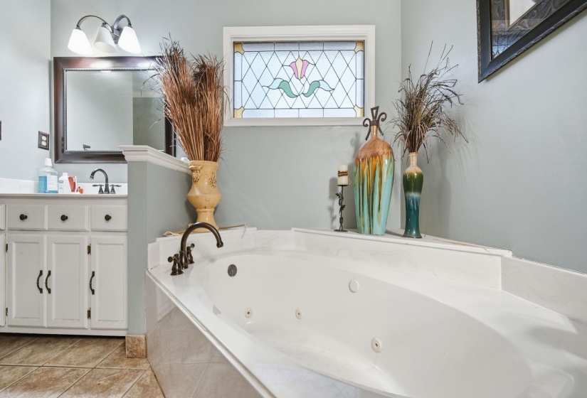 Bathroom with vanity, a whirlpool tub, and light tile patterned floors