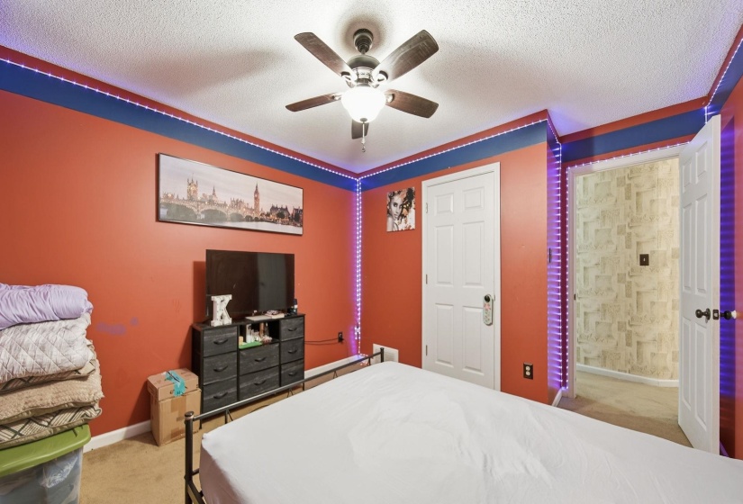 Bedroom with light carpet, a textured ceiling, and a ceiling fan