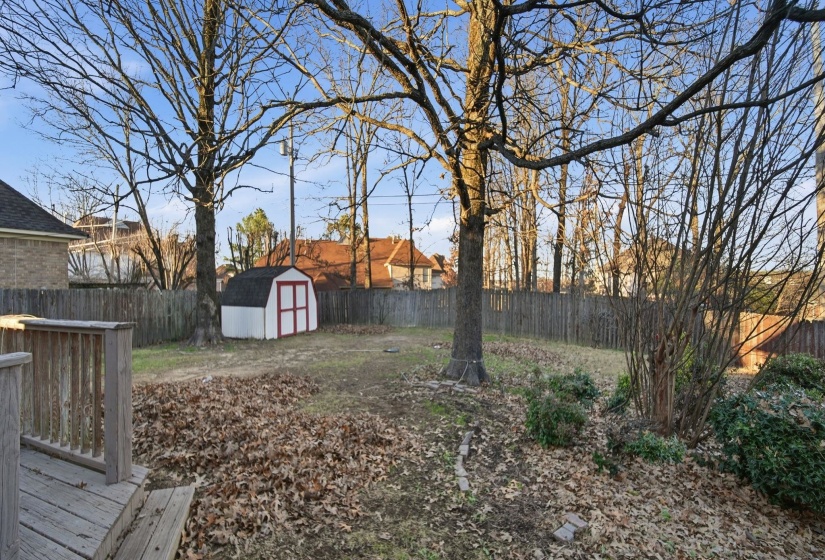 Fenced backyard with a shed and a deck