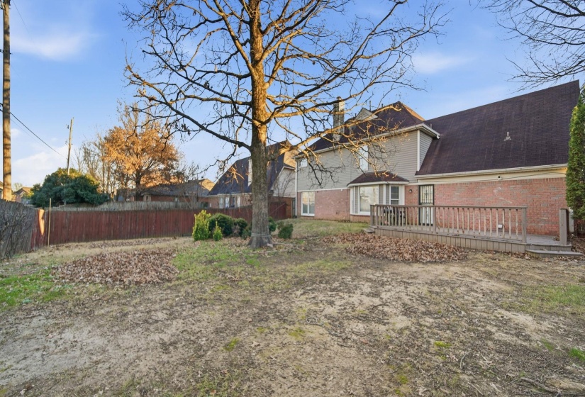 Rear view of property featuring a wooden deck, brick siding, and a shingled roof