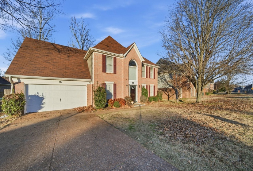 View of front of home featuring concrete driveway, an attached garage, and brick siding