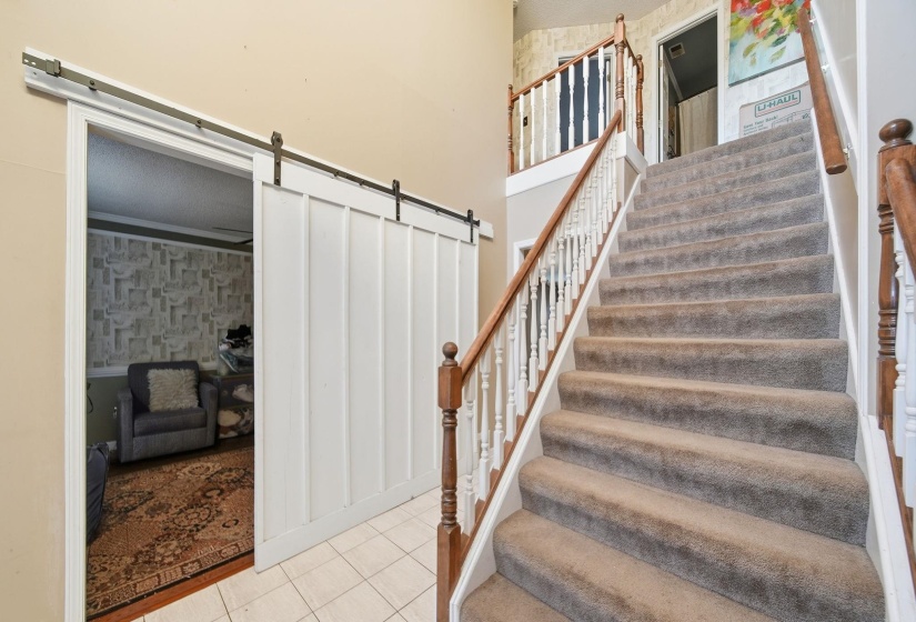 Stairway with a barn door and tile patterned flooring