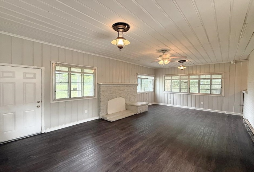 Unfurnished room featuring dark wood-style flooring, a ceiling fan, baseboards, and wooden ceiling