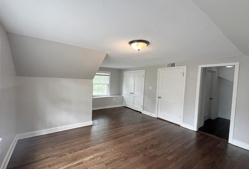 Bonus room with wood finished floors, baseboards, and lofted ceiling