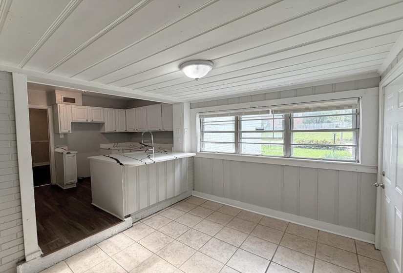 Kitchen featuring a peninsula, light tile patterned floors, and a sink