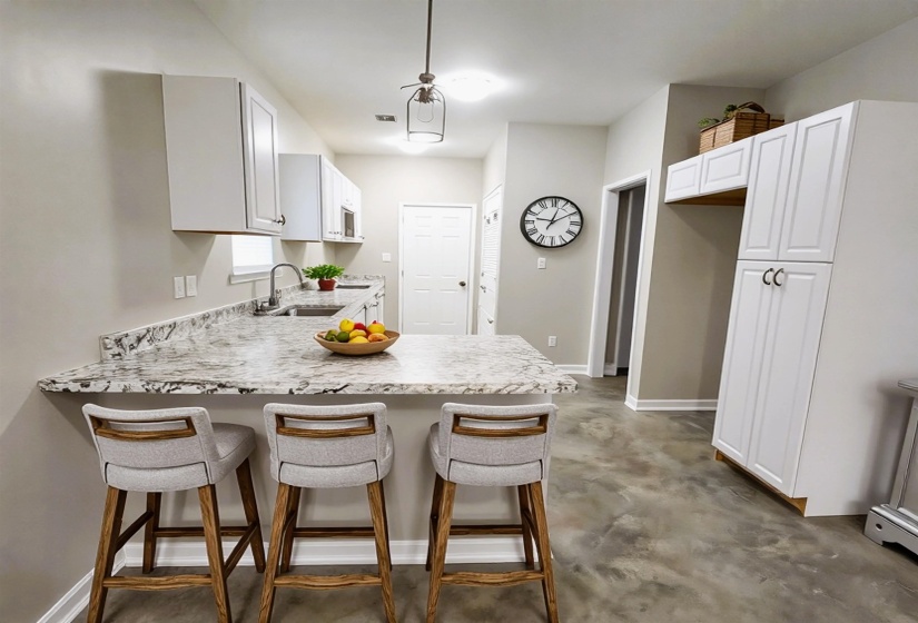 Kitchen featuring a breakfast bar, a peninsula, and open to the great room