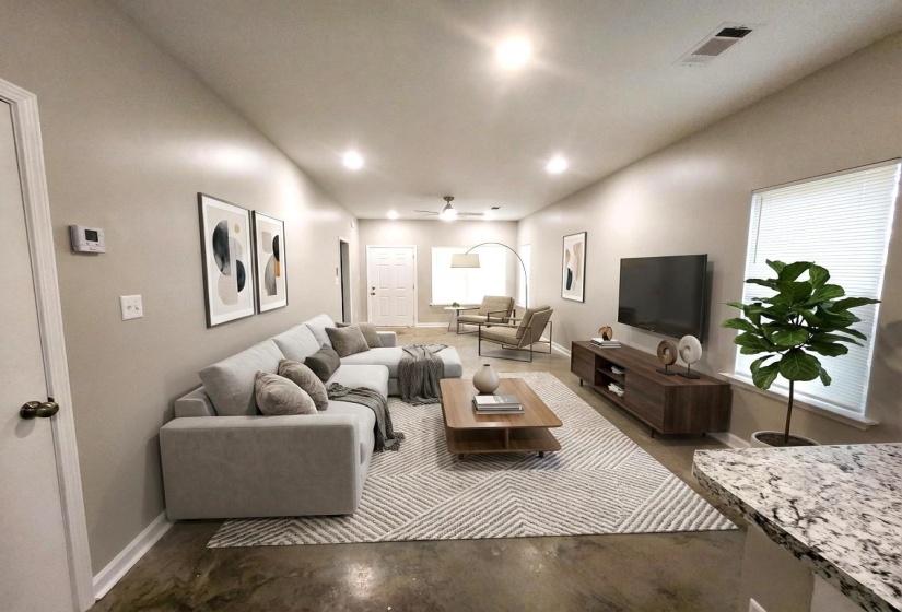 Living area with a ceiling fan, finished concrete flooring, and recessed lighting