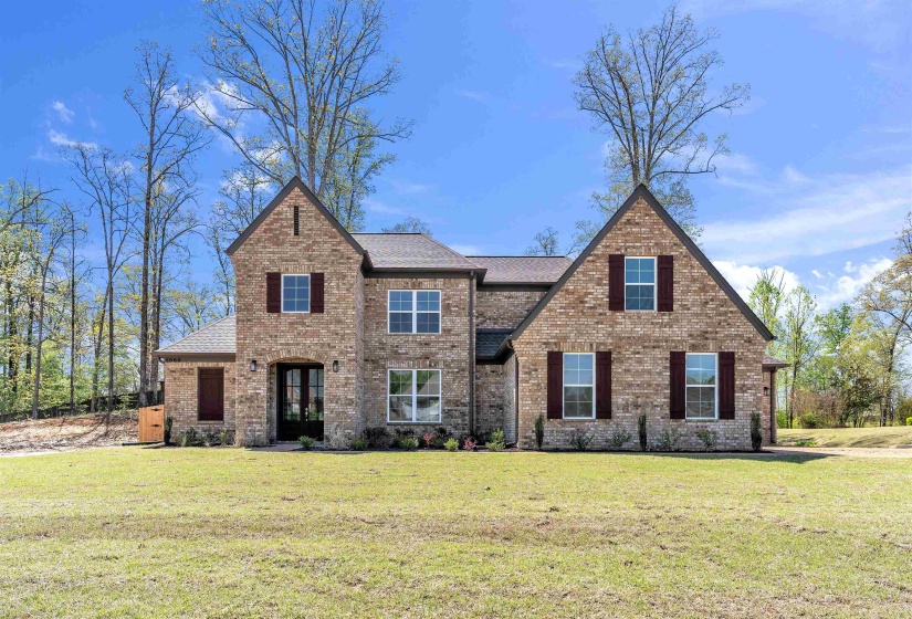 View of front of property with brick siding, a front yard, french doors, and roof with shingles